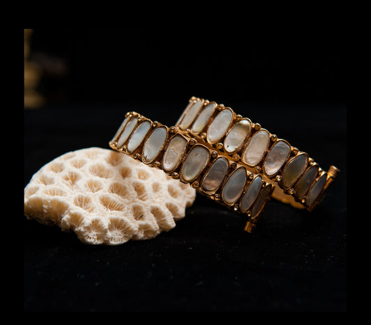 Gold bracelet with stone beads on a dark background