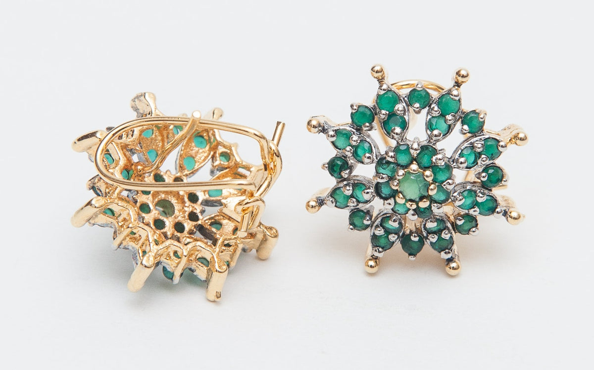 Two gold and green brooches on a light gray background