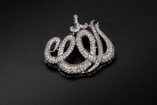 Silver 'Allah' pendant on a black background