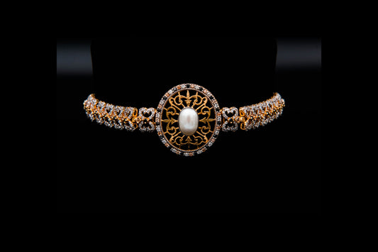 Gold and diamond bracelet with a central pearl on a black background