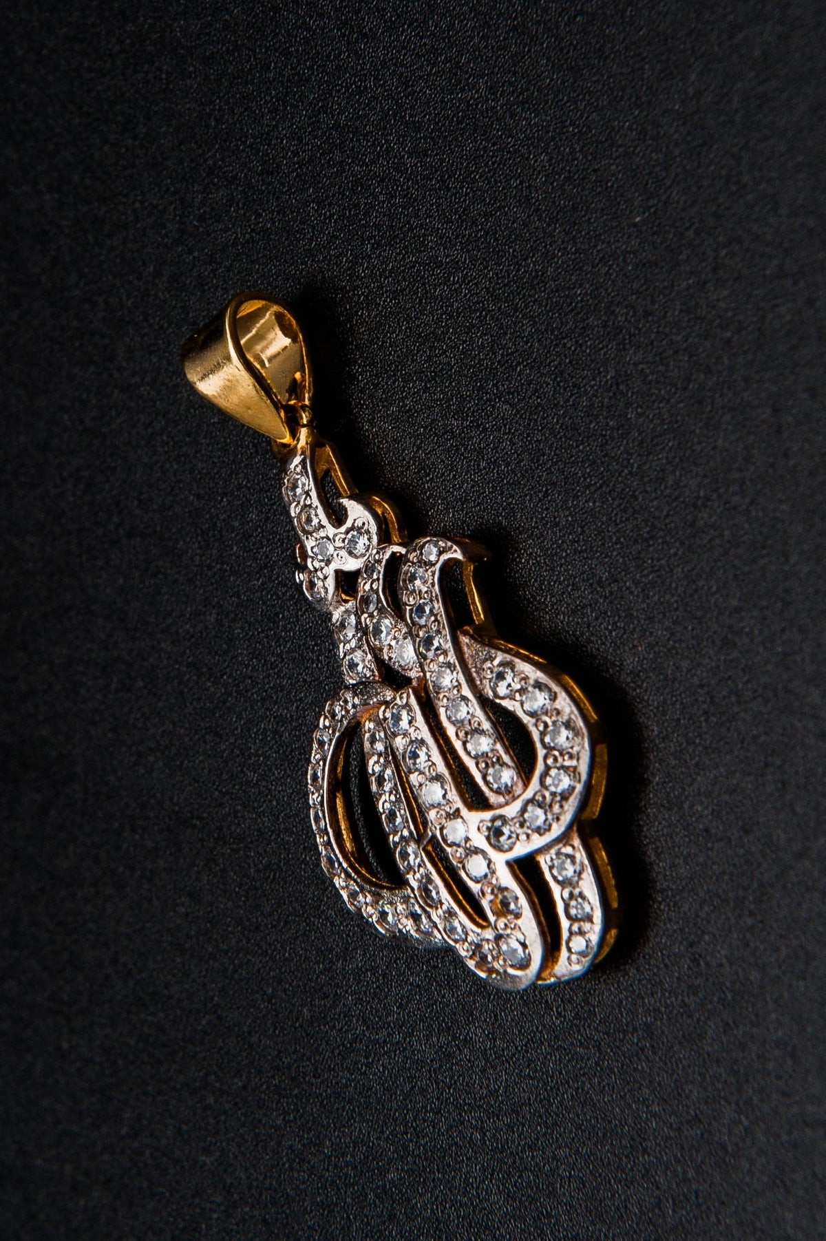 Gold and diamond pendant on a black background