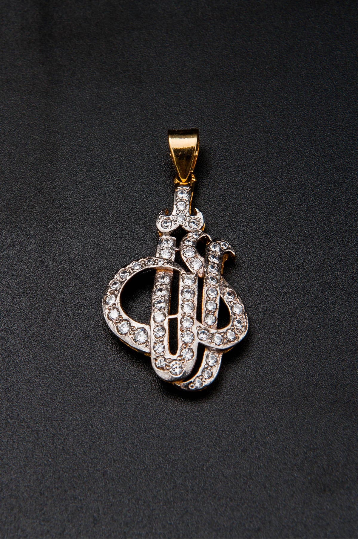 Diamond-encrusted key-shaped pendant on a black background