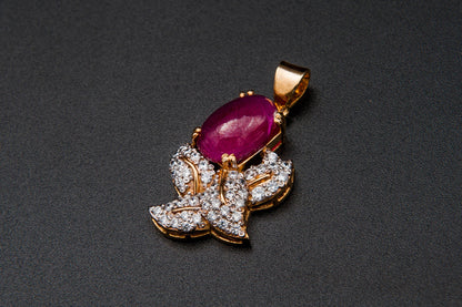 Jewelry pendant with a red gemstone and diamond accents on a dark background