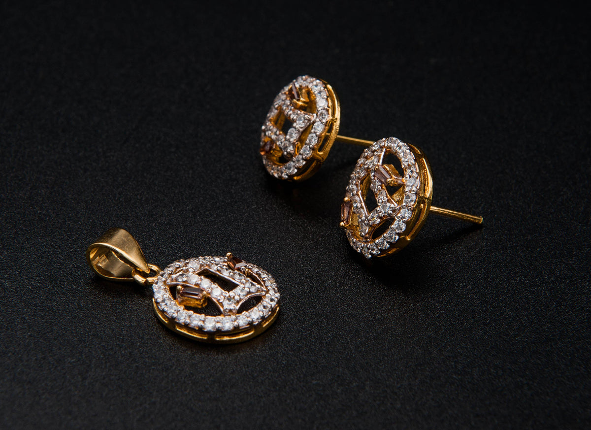Pair of gold earrings with diamond accents on a black background