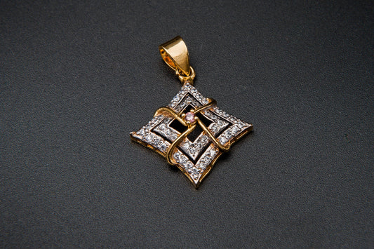 Gold and silver geometric pendant on a dark background