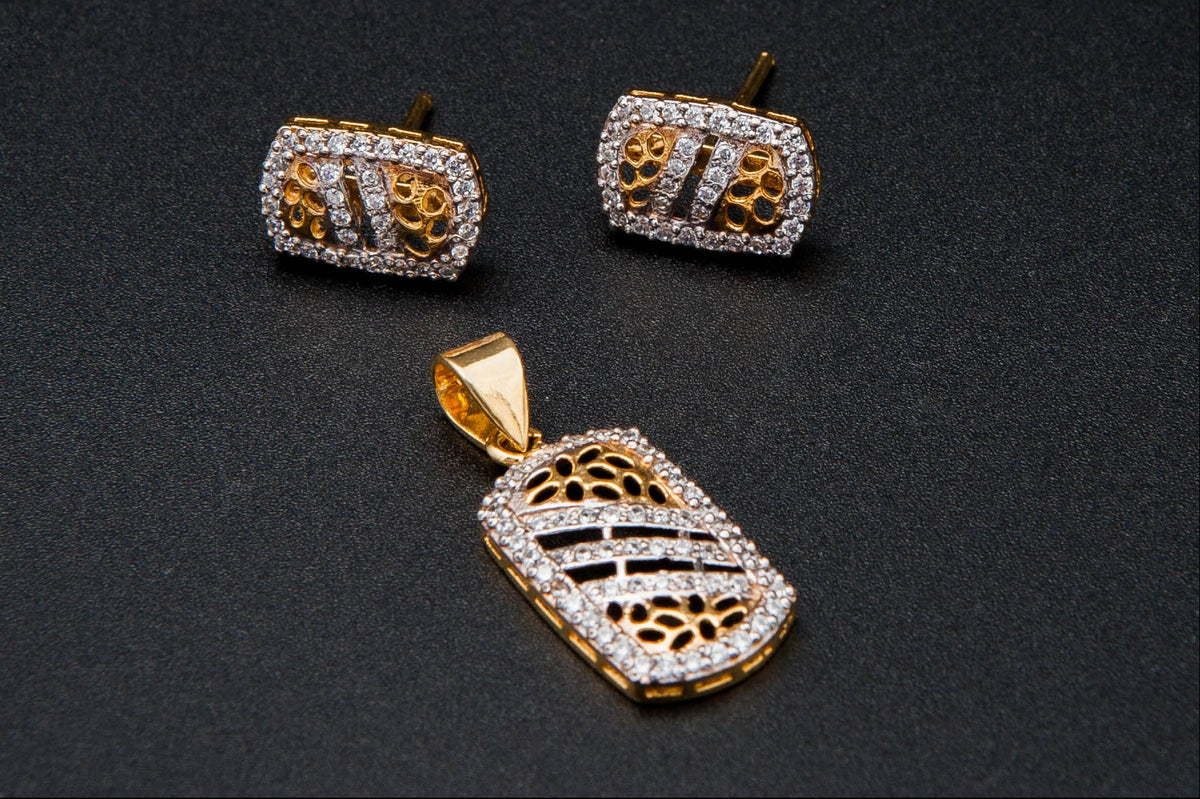 Gold earrings and pendant on a black background