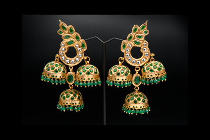 Gold and green gemstone earrings on a black background