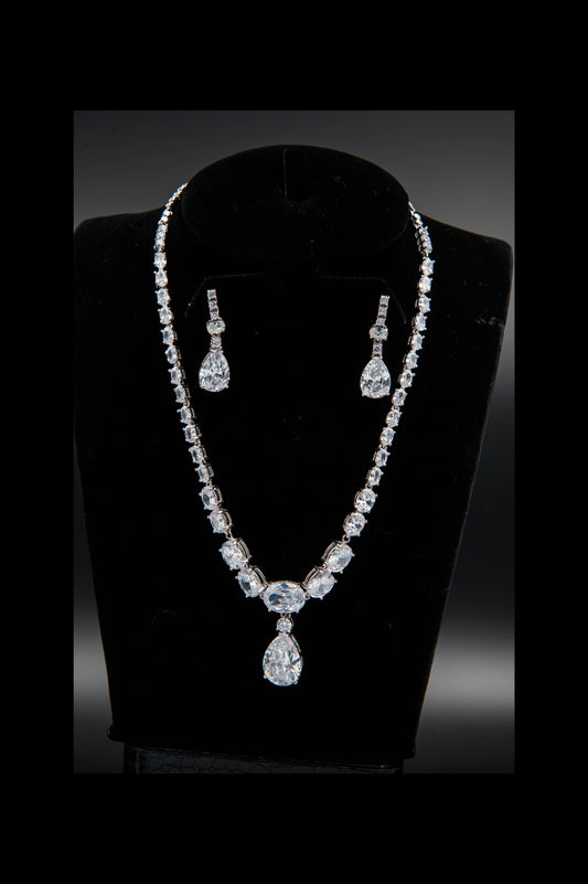 Diamond necklace and earrings set on a black mannequin bust against a dark background