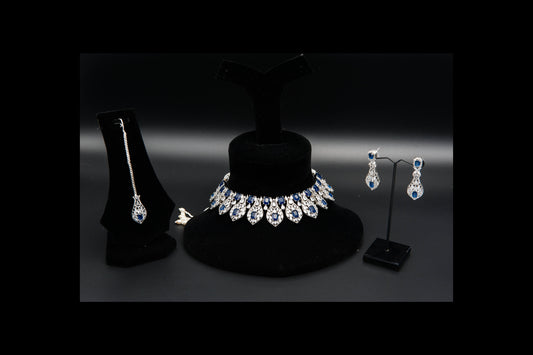 Jewelry set including necklace, earrings, and pendant on black stands against a dark background