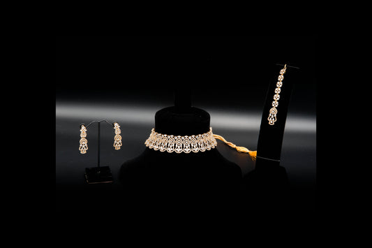 Jewelry set including a necklace and earrings on black stands against a dark background