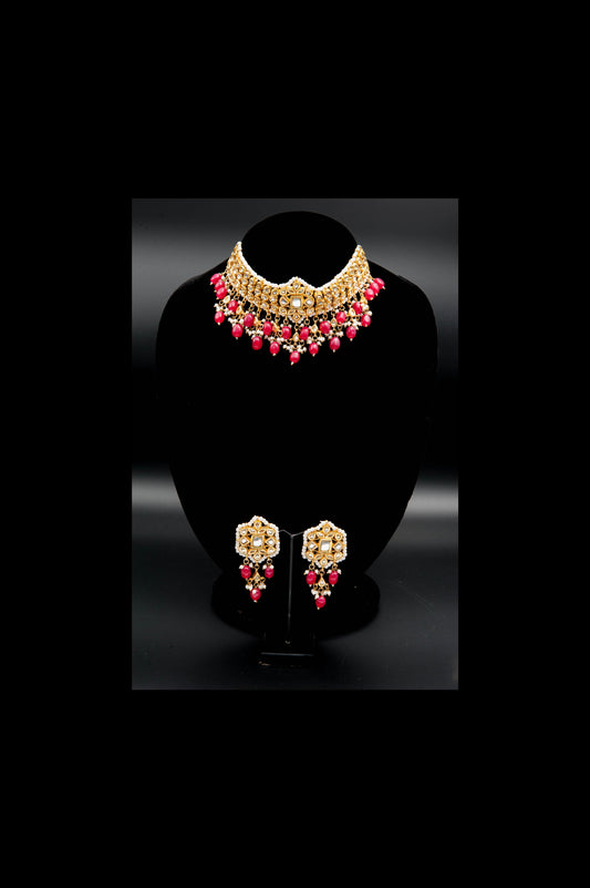 Gold and pink jewelry set on a black stand